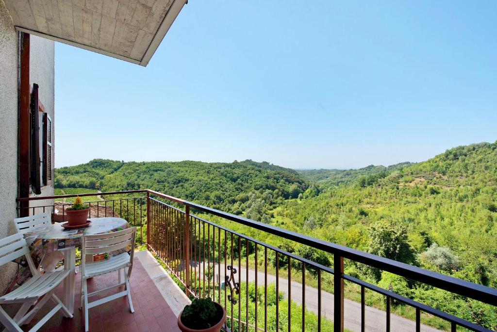 a balcony with a table and a view of the mountains at Casa Vera in Gavi