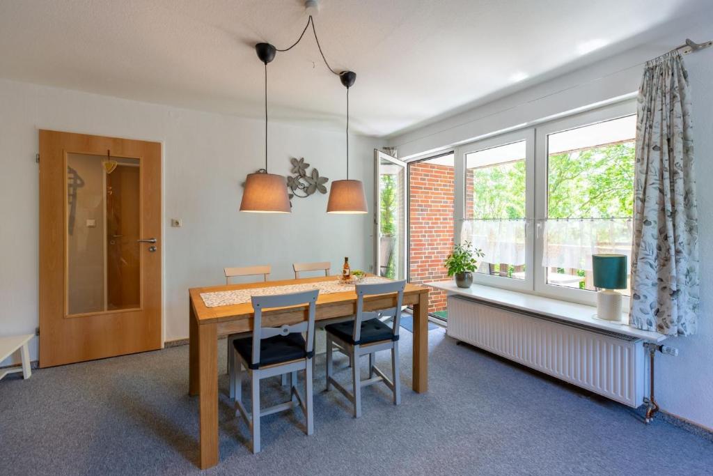 a dining room with a table and chairs and a window at Ferienhof An Der Wehle Pellworm in Pellworm