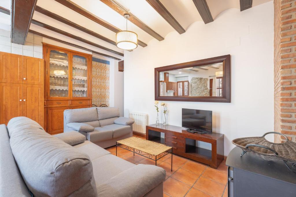 a living room with a couch and a television at Cueva Del Sereno in Chulilla