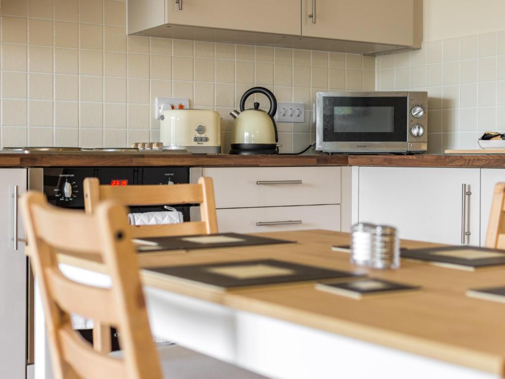 a kitchen with a table and a microwave at River Ouse Apartment in Bedford