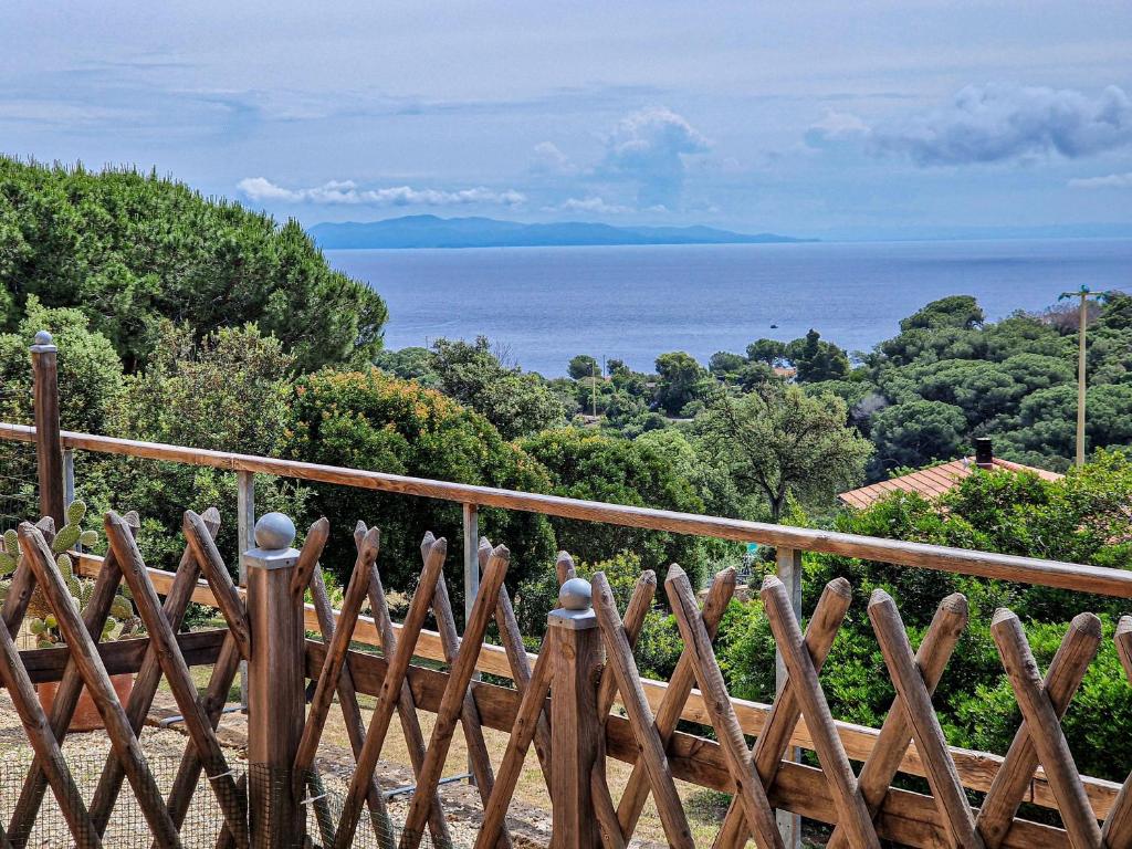 a wooden fence with the ocean in the background at Appartamenti Le Querce App. Mirto in Capoliveri
