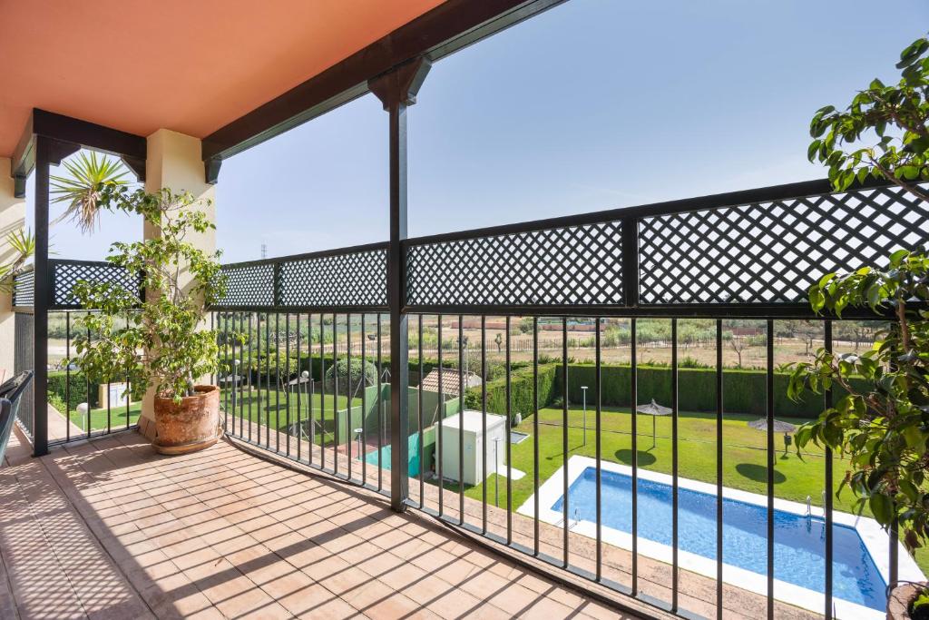 a balcony with a fence and a swimming pool at Camaleón 7 in Chipiona