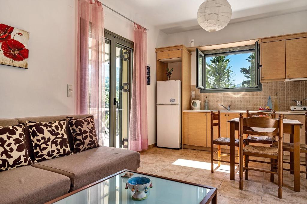 a living room with a couch and a kitchen at Alkionides Apartment 1 in Agios Nikitas