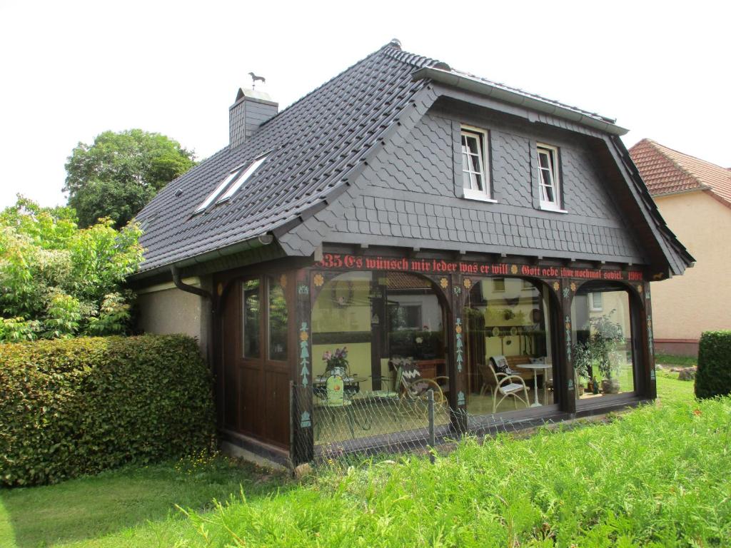 a small house with a roof on a yard at Altes Jägerhaus in Lübbenow