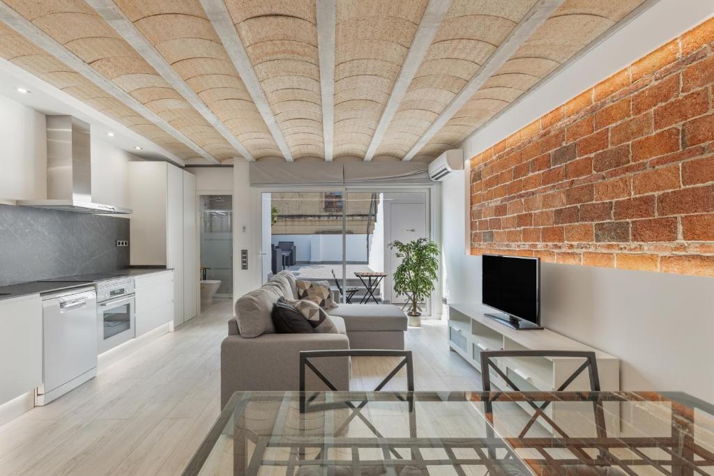 a living room with a couch and a brick wall at El racó del Mas in Canet de Mar
