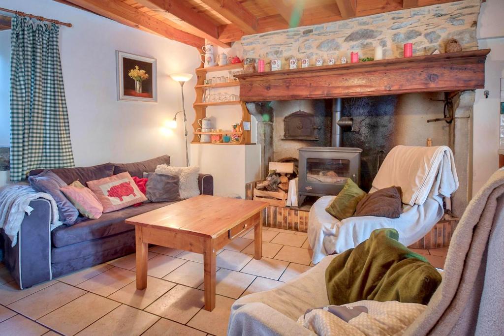 a living room with a couch and a fireplace at Maison cosy, 5 mins de St Lary in Sailhan