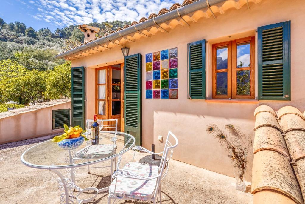 a patio with a glass table and chairs in front of a house at Casa Catalina in Sóller