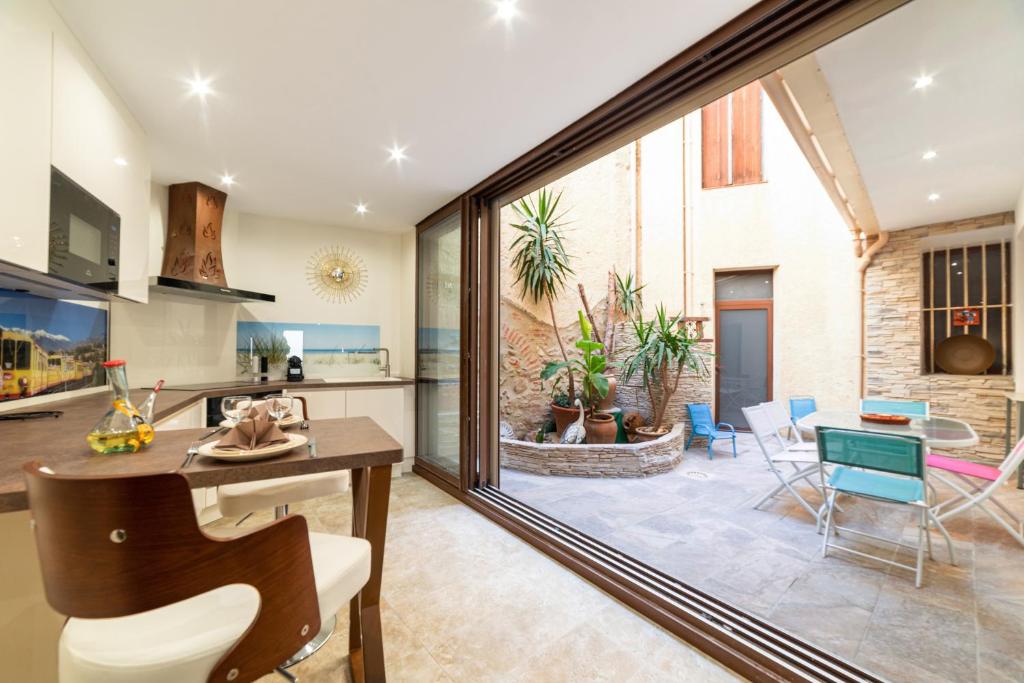 a kitchen and living room with a large glass window at Plaisir des pierres in Rivesaltes