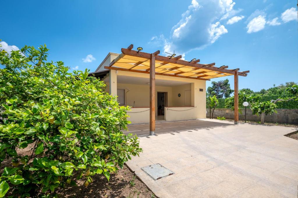 an outdoor patio with a wooden pergola at Villa Minetta in Leporano Marina