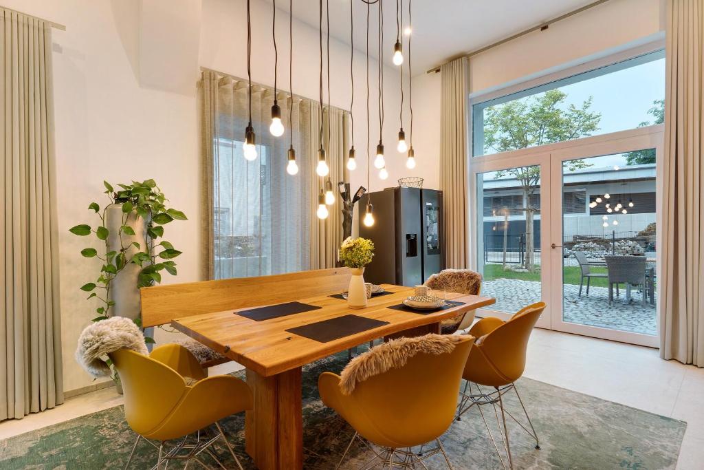 a dining room with a wooden table and yellow chairs at Gästehaus Achern in Achern