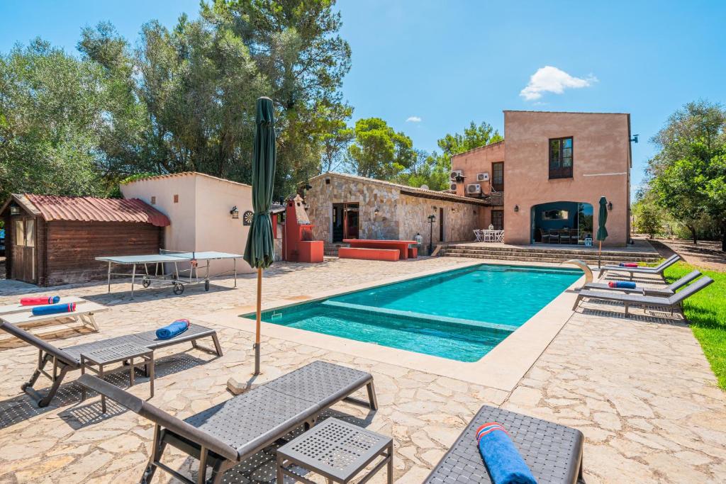 an outdoor swimming pool with chairs and a house at Son French in Algaida