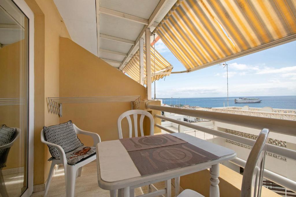 a balcony with a table and chairs and a view of the ocean at Ceyla in Arona
