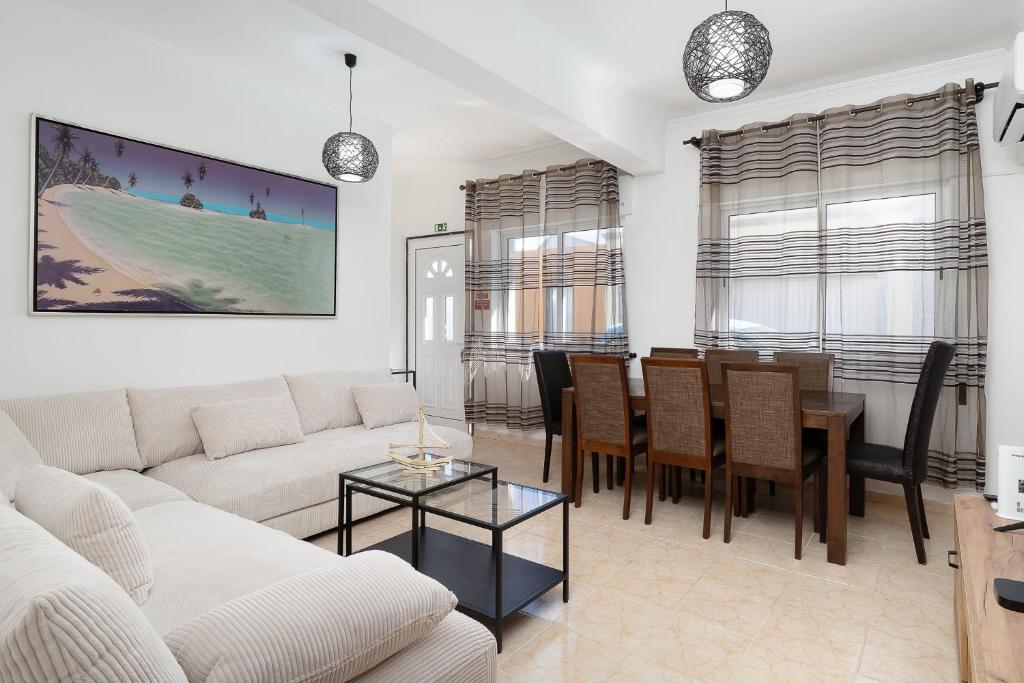 a living room with a couch and a dining room at Casa Linda in Olhão