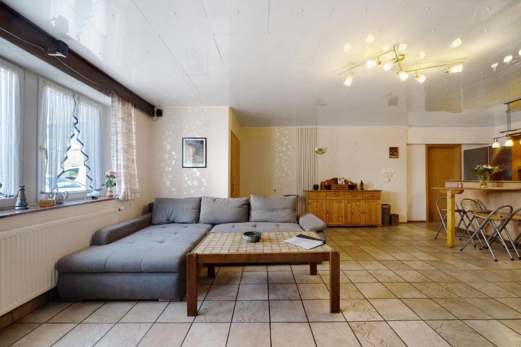 a living room with a blue couch and a table at Ferienwohnung Wiesental in Meisburg