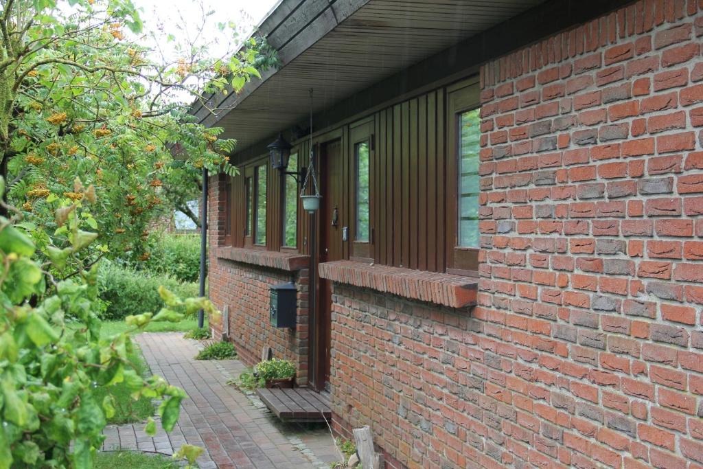 a brick building with a porch and a brick walkway at Ferienhaus am Belmermoor 167 in Brunsbüttel