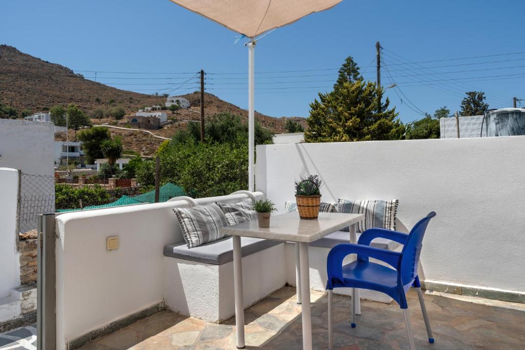 a table and chairs on a balcony with an umbrella at Pico Bello Patmos 10 in Patmos