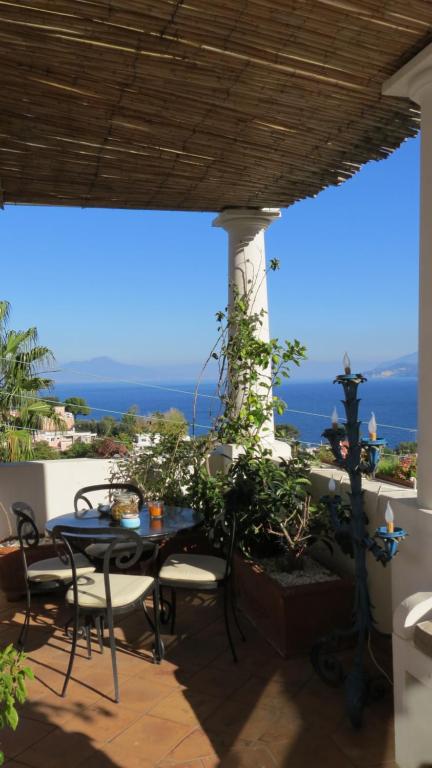 une terrasse avec une table et des chaises et l'océan dans l'établissement Scala Fenicia 14 by CapriRooms, à Capri