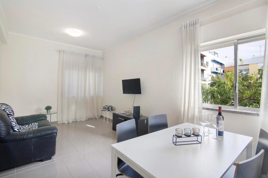 a living room with a white table and a couch at Matinhos House in Faro