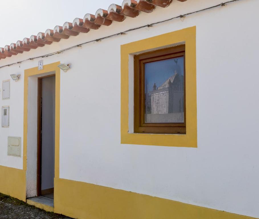 a building with a window and a reflection of a building at Casa 5 Flores in Odeceixe
