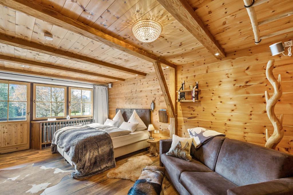a log cabin bedroom with a bed and a couch at Chalet Gipfelblick Inzell in Inzell