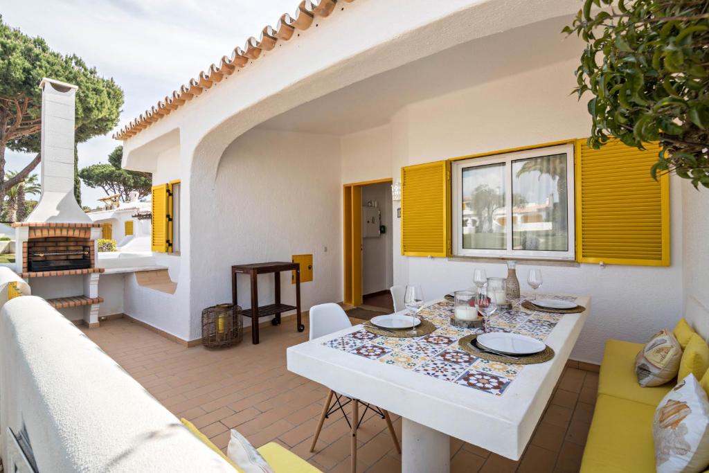 a white table and chairs on a patio with a fireplace at Casa O12 in Vilamoura