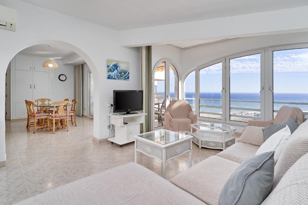 a living room with a couch and a table with a television at Apartamento Laolita in Torrox