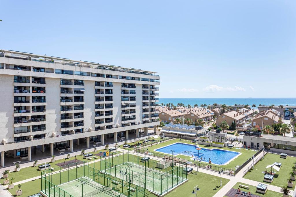 a large building with a pool in front of it at Valencia Playa in Valencia