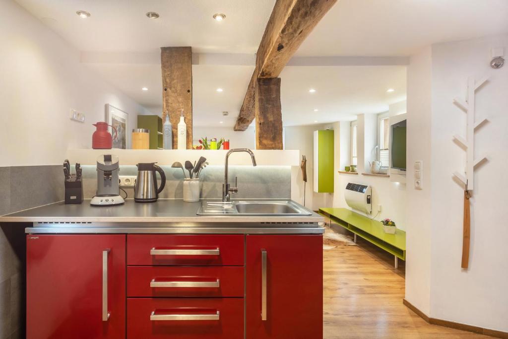 a kitchen with red cabinets and a sink at Ferienhaus Mittendrin in Jesberg