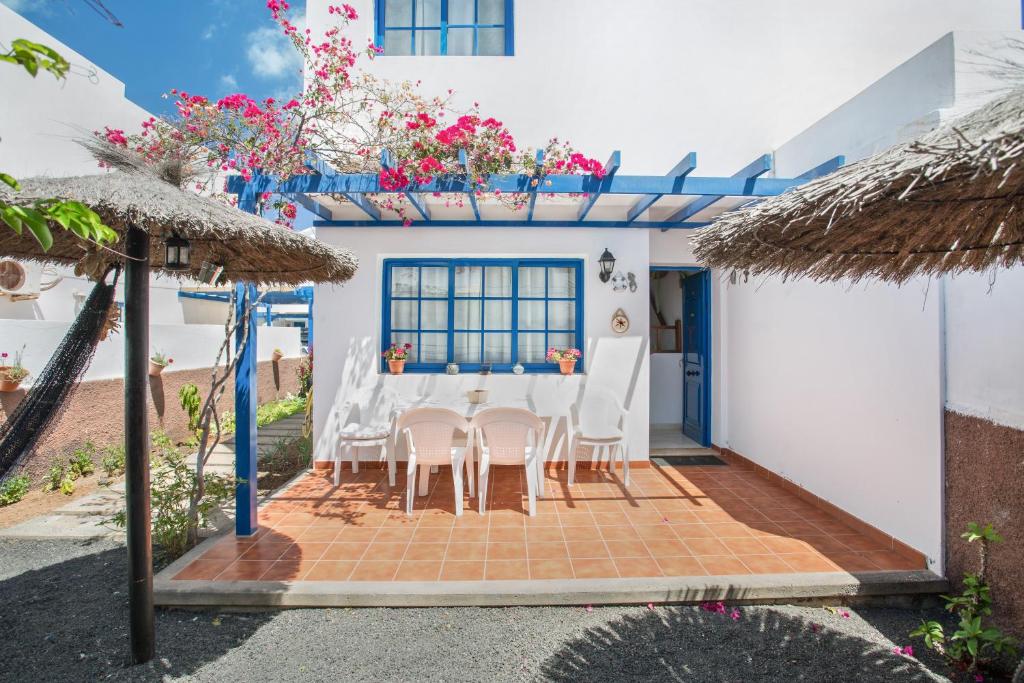 a dining room with a table and chairs in front of a house at Casa Rosa in Yaiza