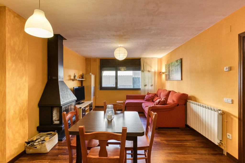 a living room with a table and a fireplace at Cal Tatanet in Sant Pau de Segúries