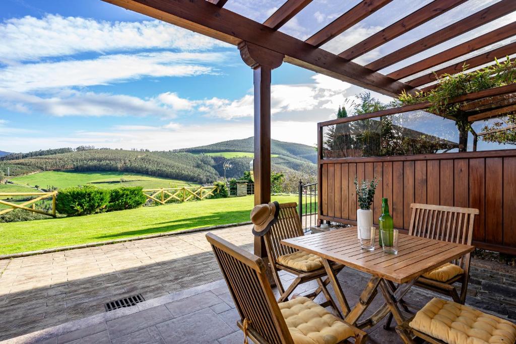 a wooden table and chairs on a patio with a view at L de Alborada del Eo in Villameitide