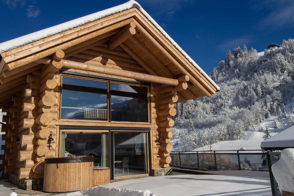 a log cabin with a view of a snow covered mountain at Chalet Zwoasom in Grossarl