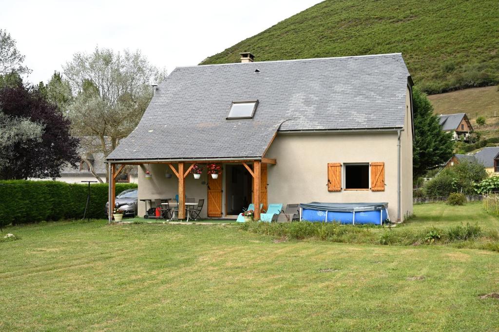 a small white house with a hill in the background at Jolie Maison Vallee D'aure 4étoiles in Pailhac