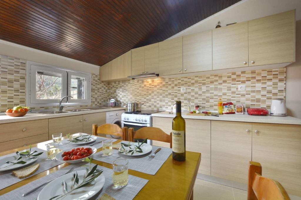 a kitchen with a table with a bottle of wine at Erietas House in Ágios Matthaíos