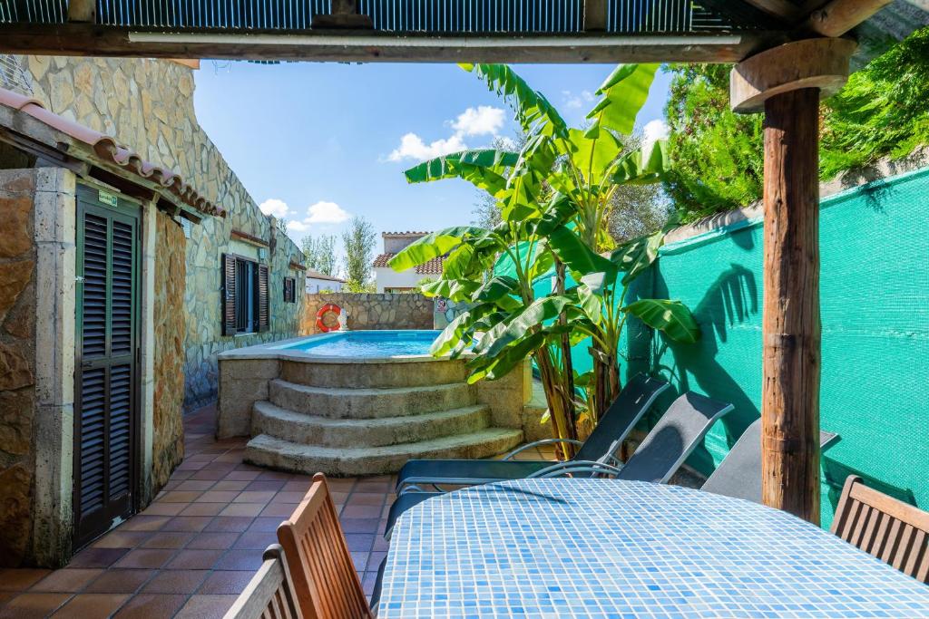 a patio with a table and chairs and a swimming pool at Casa Paqui Alcudia in Port d'Alcudia