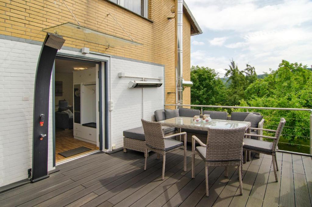 a patio with a table and chairs on a deck at Harzblick am Waldesrand in Hahausen
