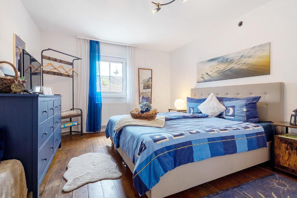 ein Schlafzimmer mit einem blau-weißen Bett und einer Kommode in der Unterkunft Lindenhardt in Creußen