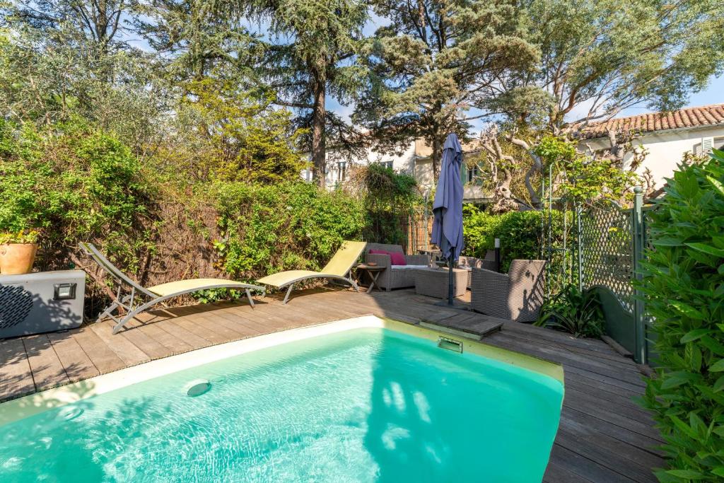 a swimming pool with a deck and chairs next to a house at Studio avec piscine à Avignon in Avignon