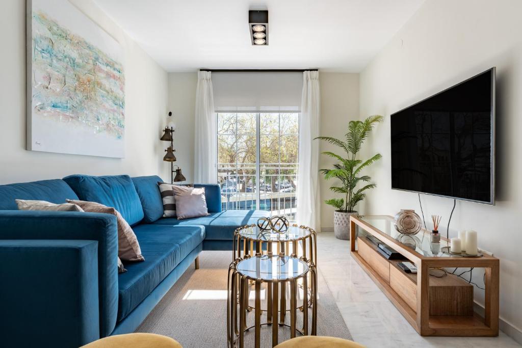 a living room with a blue couch and a tv at Mirage Mijas centro in Mijas
