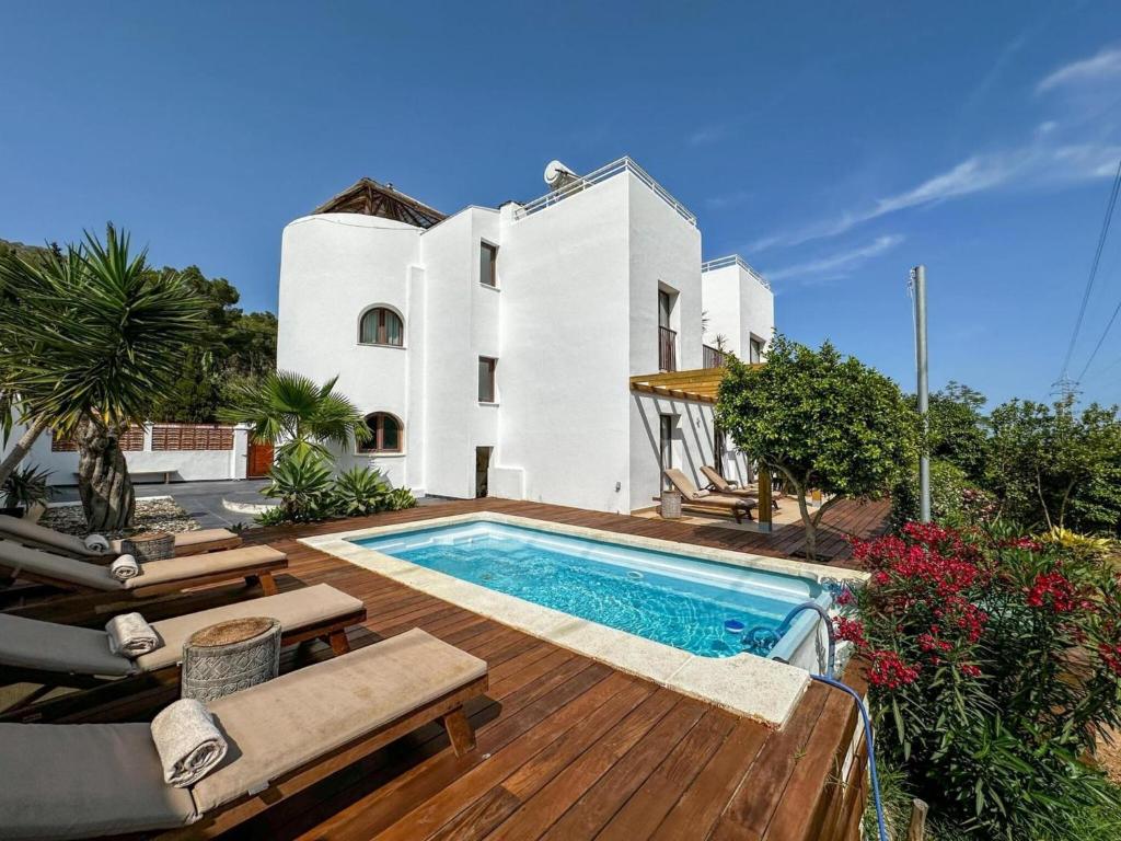 a swimming pool in front of a house at Villa Retreats in Santa Eularia des Riu