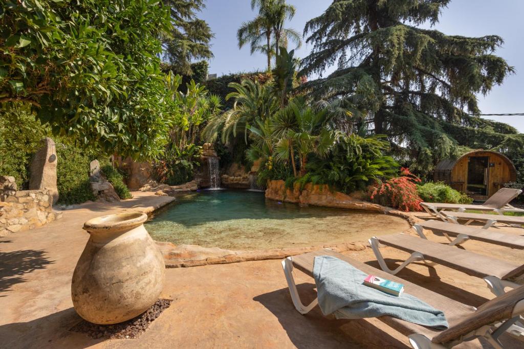 a swimming pool with a vase and a table and chairs at Mas Juli in Pineda de Mar