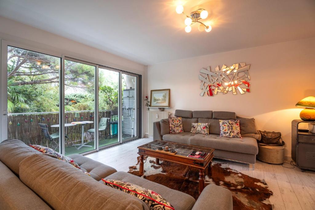 a living room with a couch and a table at Appartement Atypique avec terrasse in Hyères