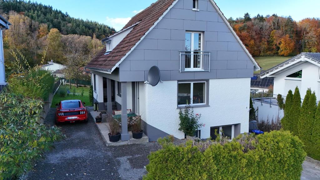 a white house with a red car parked in front of it at Ferienhaus Spes in Stockach