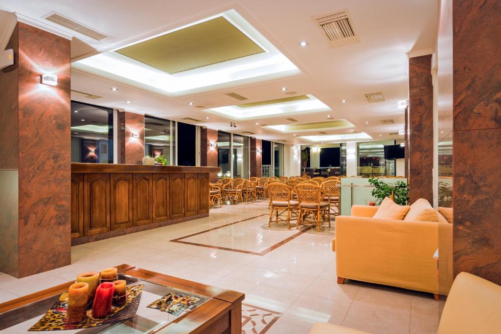 hol z kanapą, stołem i krzesłami w obiekcie Akrata Beach Hotel w mieście Akrata