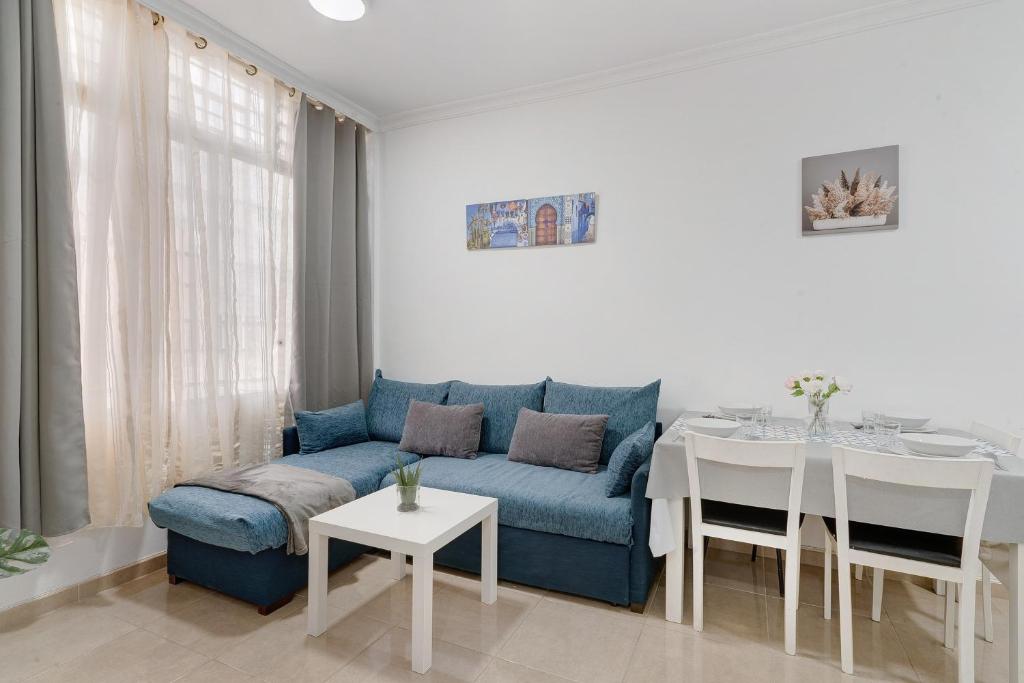 a living room with a blue couch and a table at Un descanso 2 in San Fernando