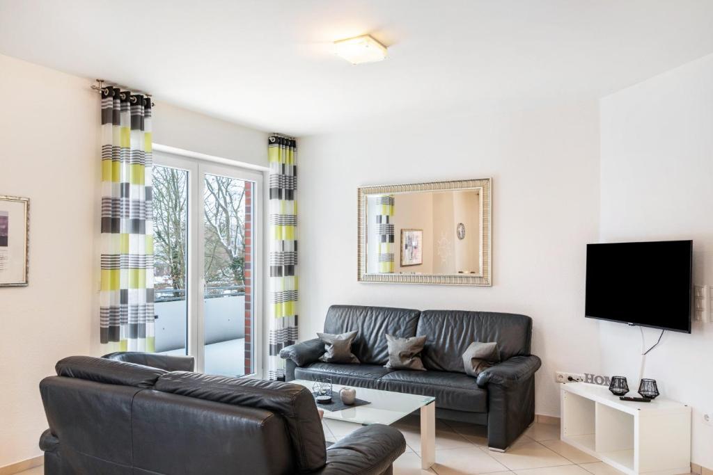 a living room with a couch and a tv at Ferienwohnung Hilbers in Horumersiel