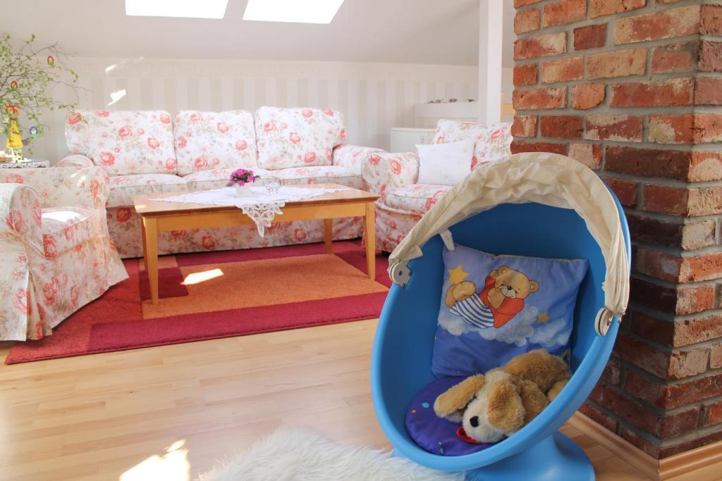 a baby crib with a teddy bear in it in a living room at Märchengarten Fischer un sin Fru in Putbus