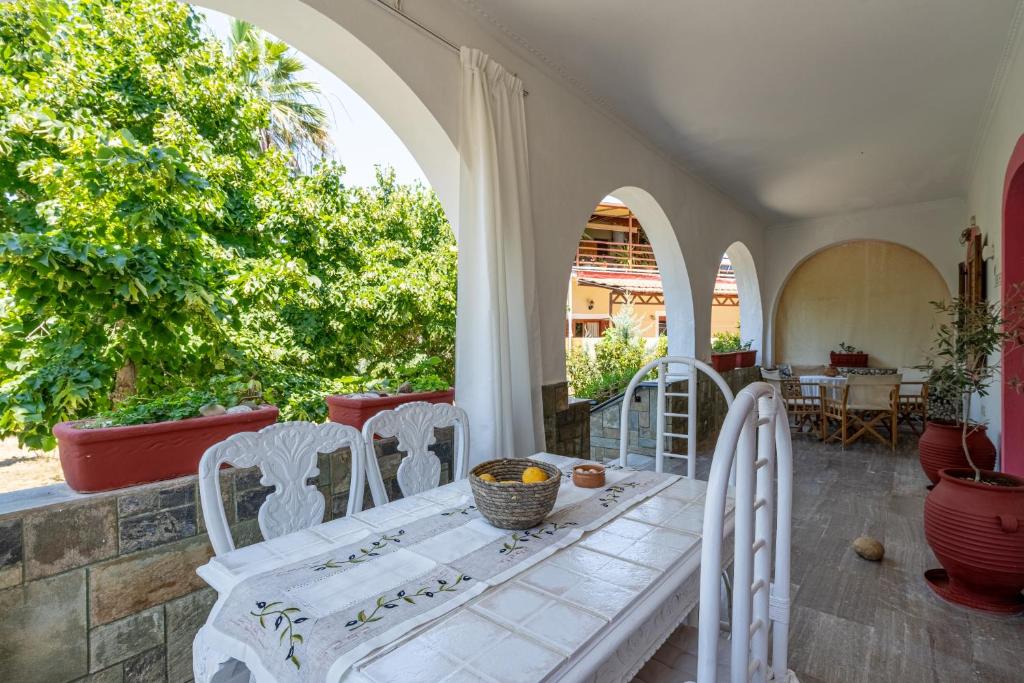 a patio with a table and chairs on a porch at House Theodora holidays Greece in Dragotiná