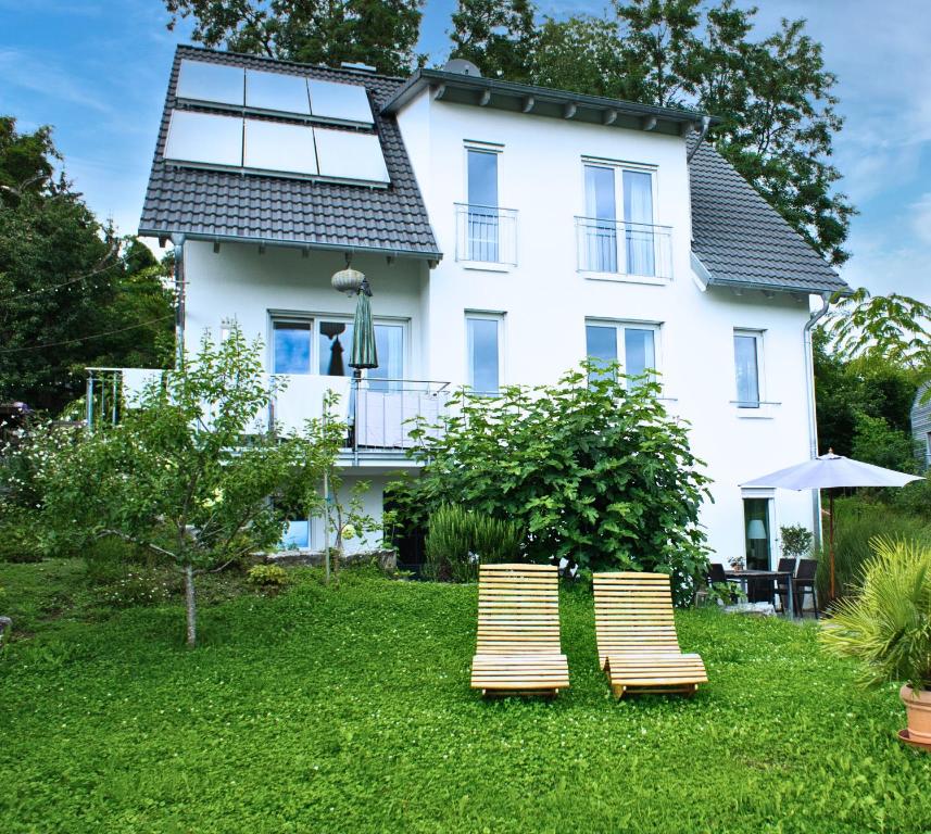 two lounge chairs in front of a house at Ferienwohnung Im Laubgarten in Öhningen