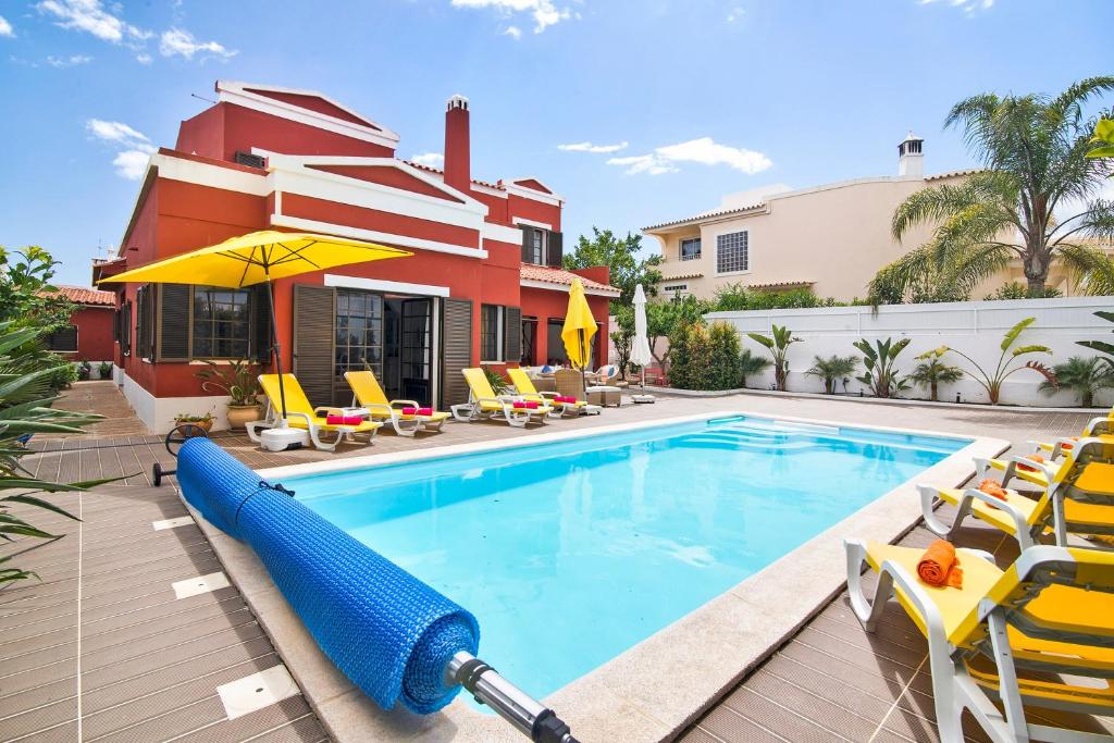 a swimming pool with a inflatable raft in front of a house at Sunshine House in Faro